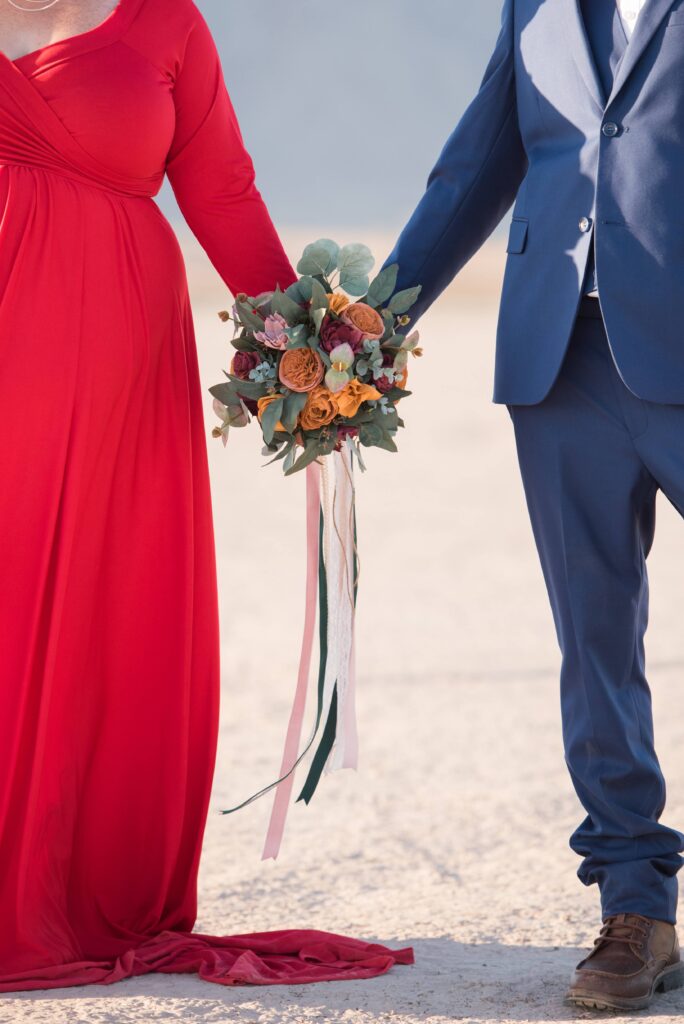 a couple holding a desert themed wood flower bouquet