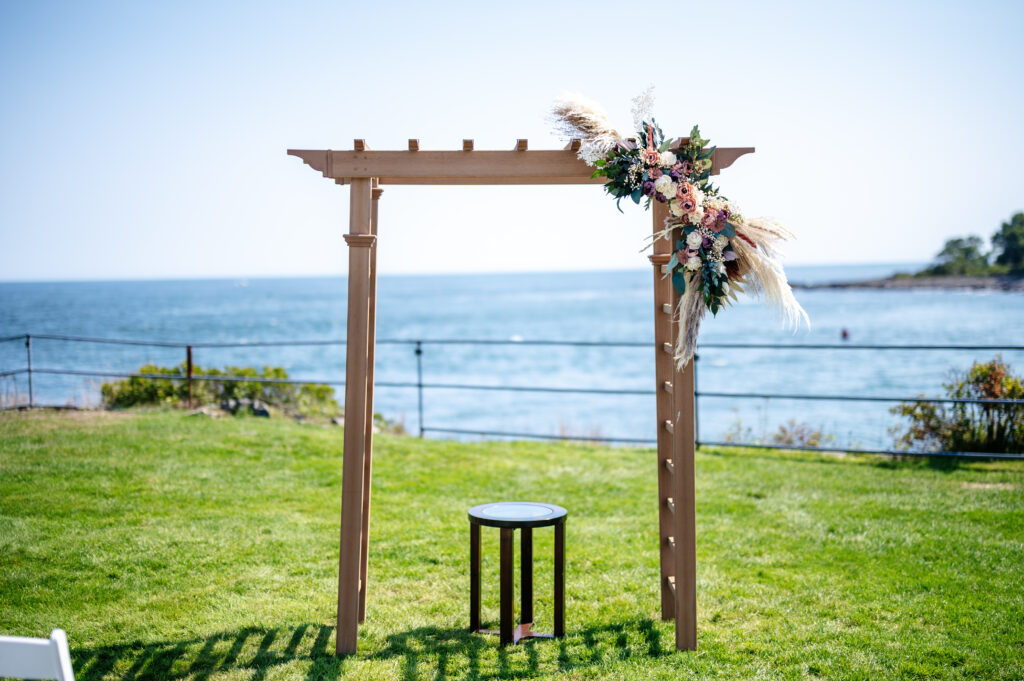 wedding ceremony arch decorated with boho wood flower swag decor